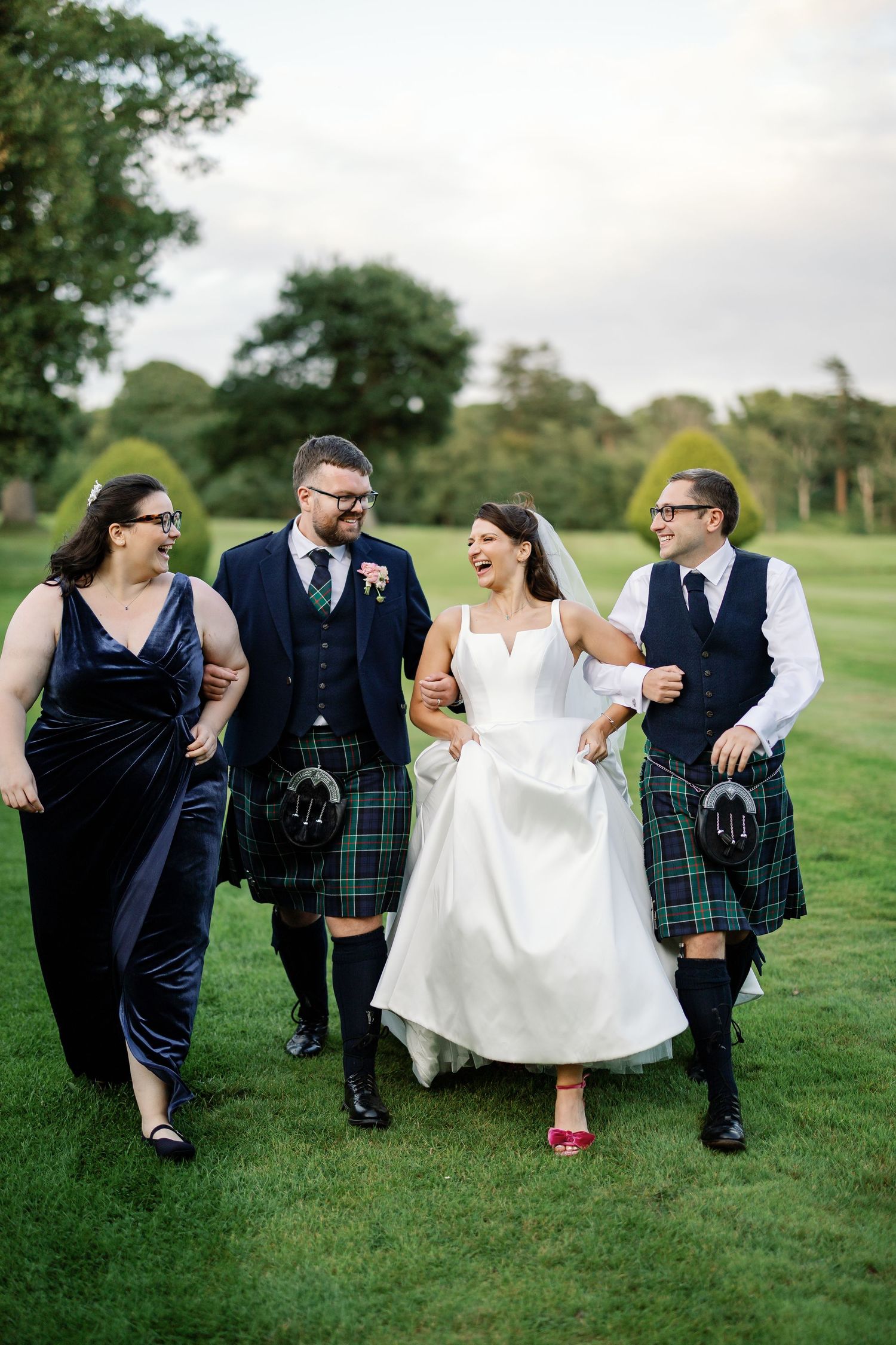 “Bride and groom standing in front of Kinmount House, a stately Scottish mansion with sweeping lawns and classic architecture.”