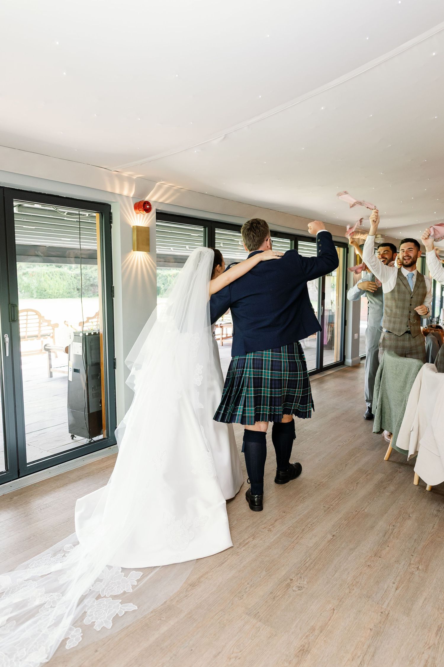 A sequence of dance moves captured in five frames showing people in wedding attire performing coordinated movements.