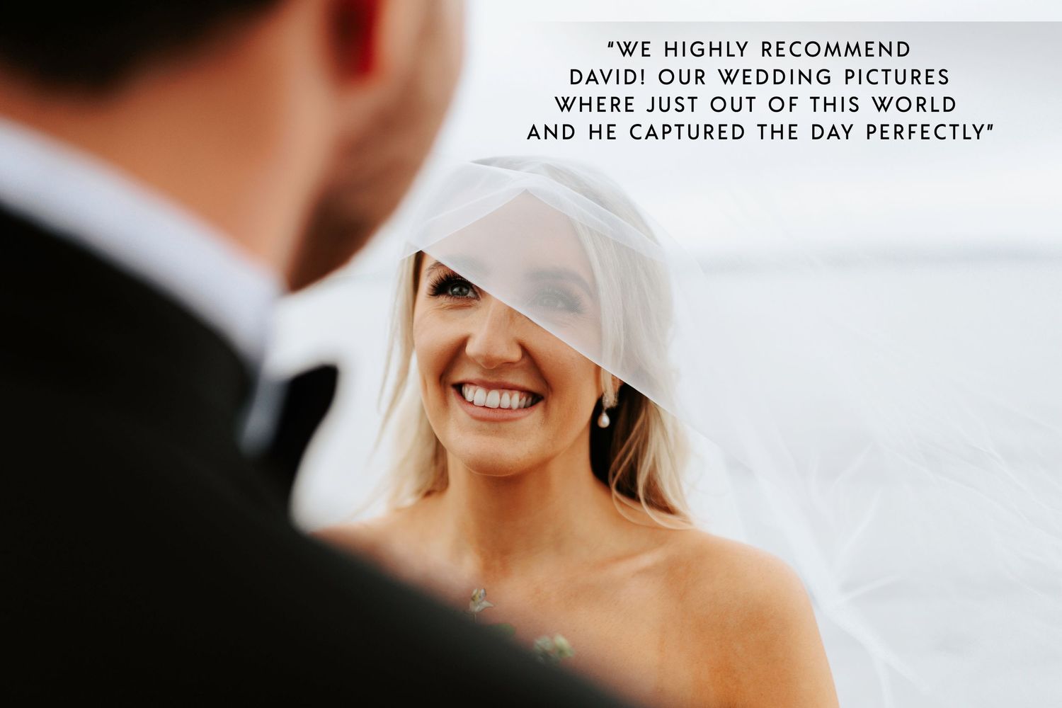 A joyful candid moment between a bride and groom during their outdoor wedding ceremony.
