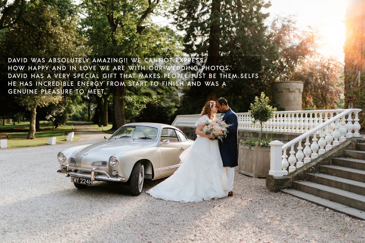 Classic Volkswagen Karmann Ghia parked next to ornate white stone staircase at sunset during wedding celebration.