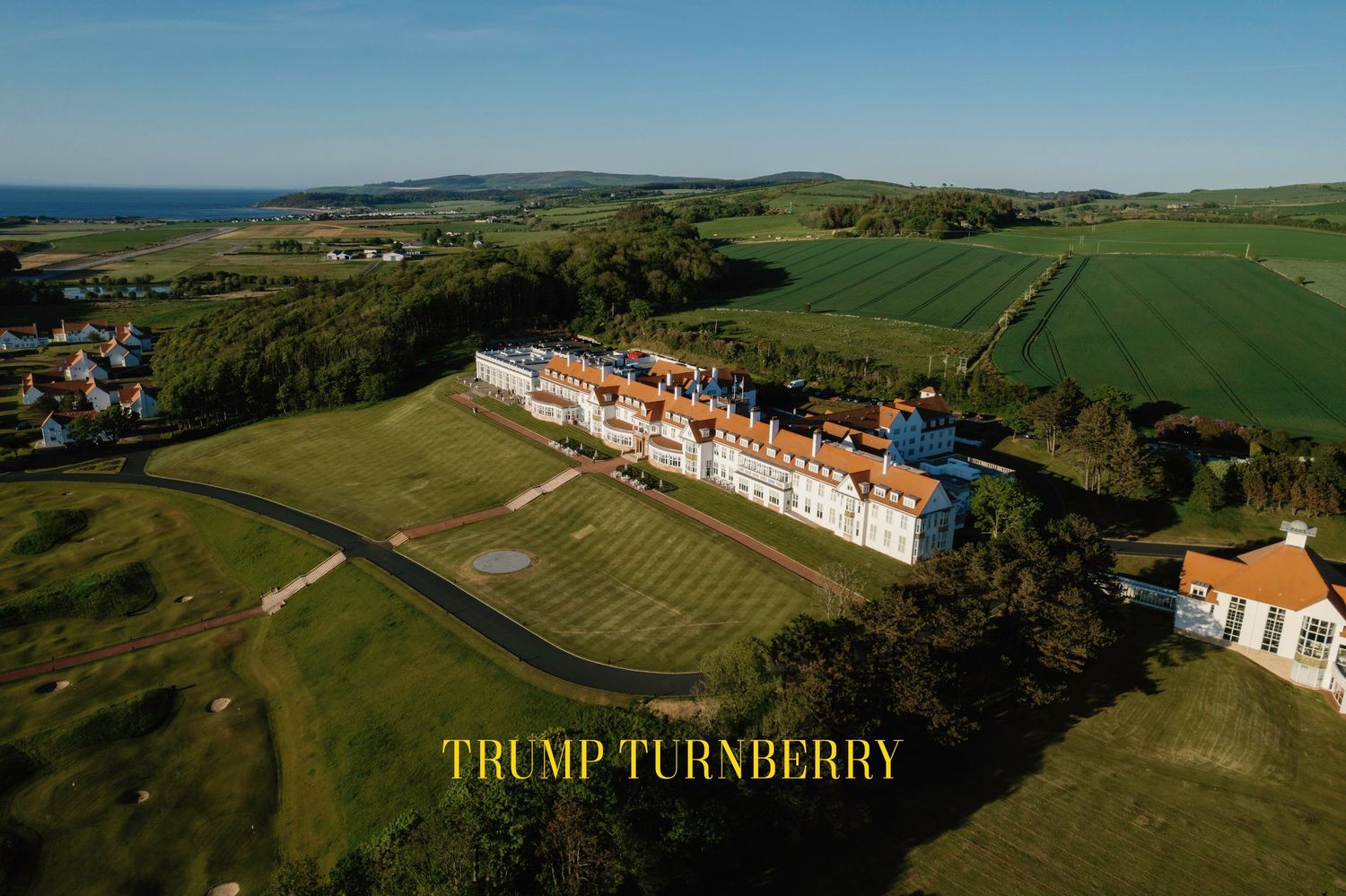 Aerial view of Trump Turnberry luxury golf resort and hotel overlooking the Scottish coastline and green fields. Stunning wedding venue