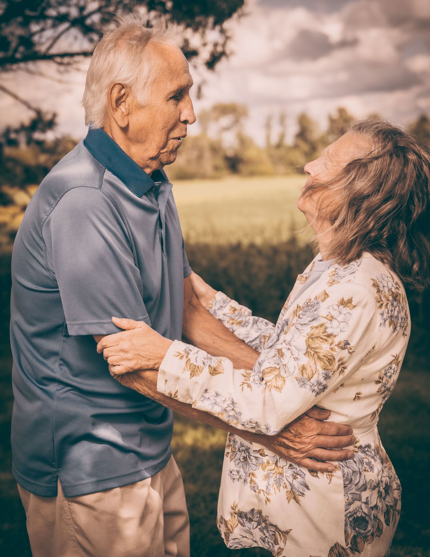 Senior couple sharing an intimate moment outdoors in golden afternoon light.