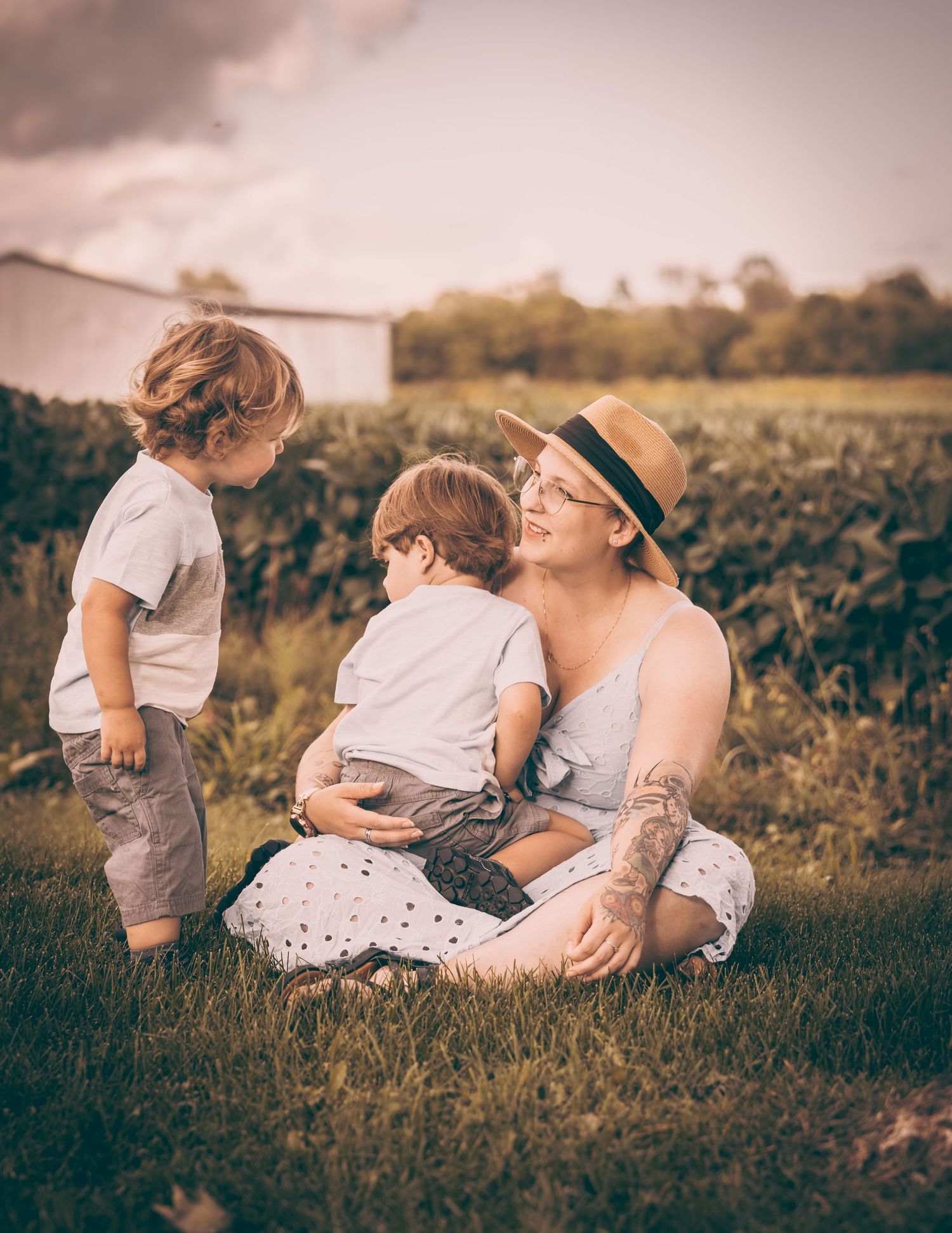 A tender outdoor family moment captured between parent and children in soft vintage tones.