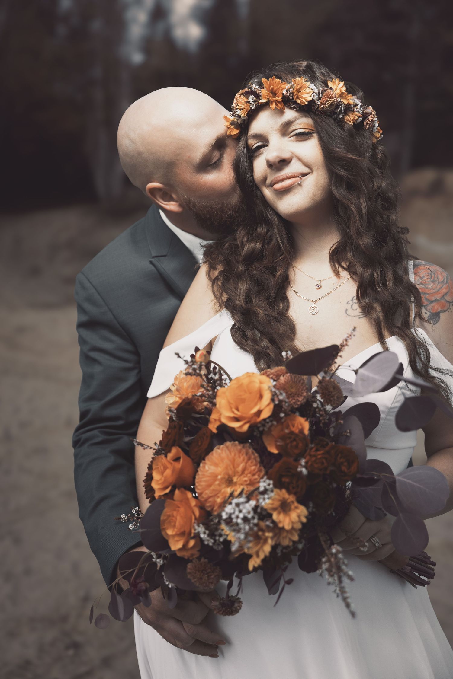 A romantic wedding moment with orange roses and fall-inspired floral details.
