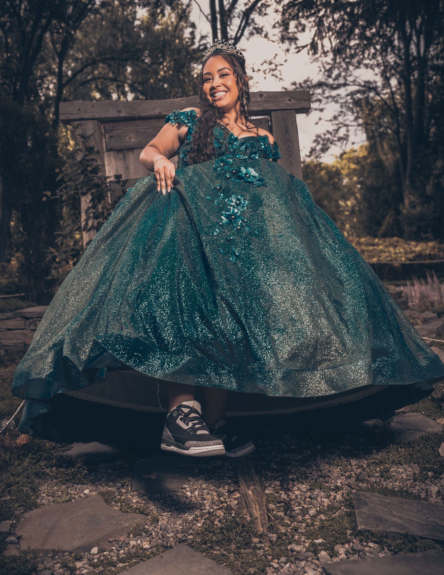 A sparkling teal ballgown contrasted with casual sneakers in an outdoor garden setting.