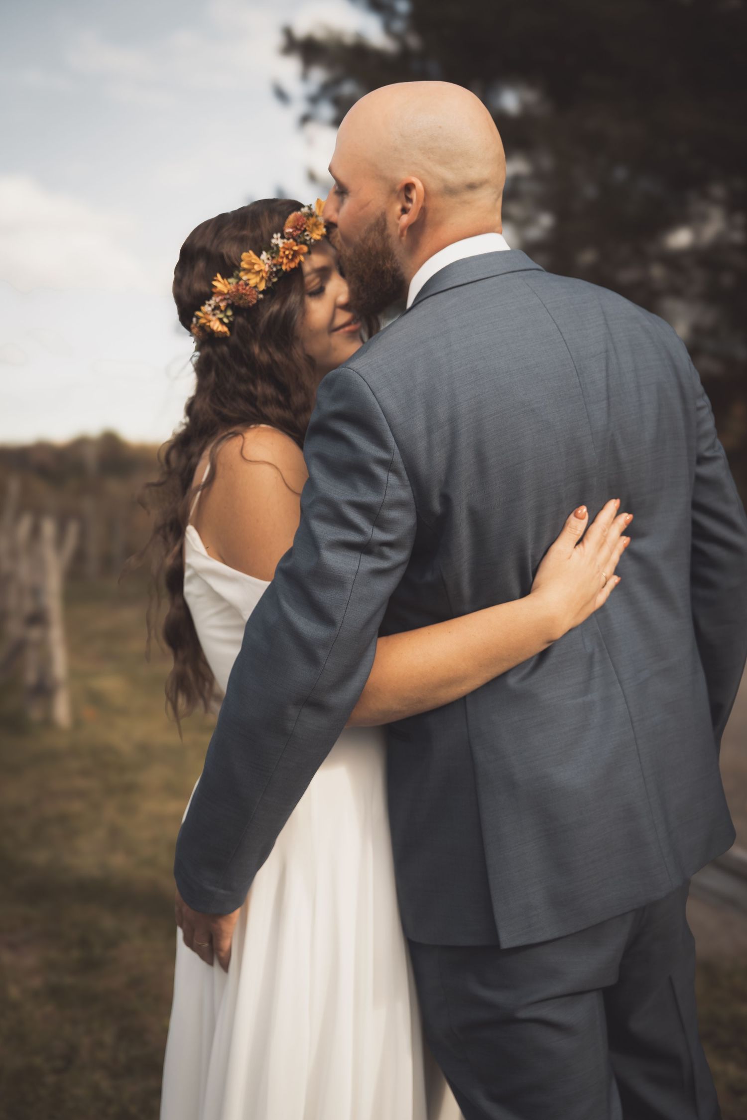 A romantic wedding moment shows a couple embracing, with the bride wearing a white dress and delicate floral crown.