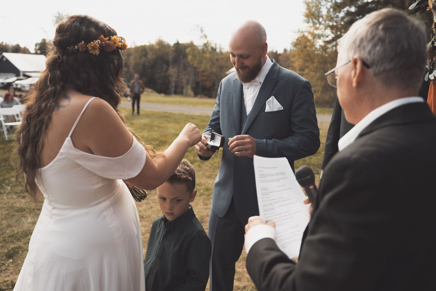 Wedding ceremony moment outdoors with couple exchanging vows.
