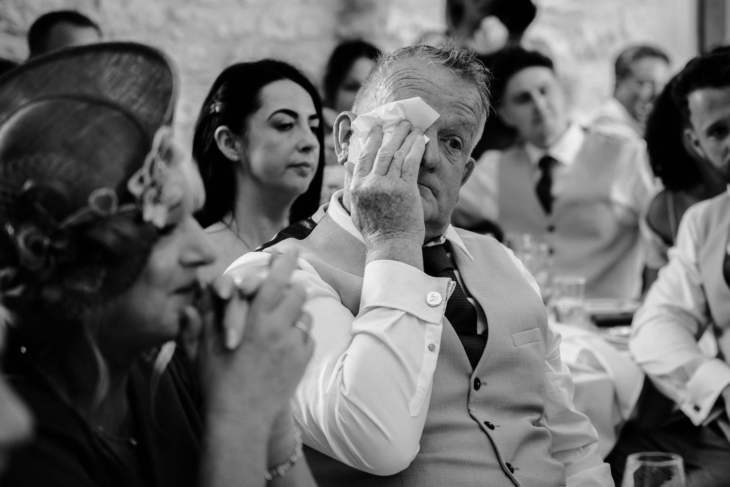 Black and white photo of wedding guests enjoying a celebratory moment at a reception.