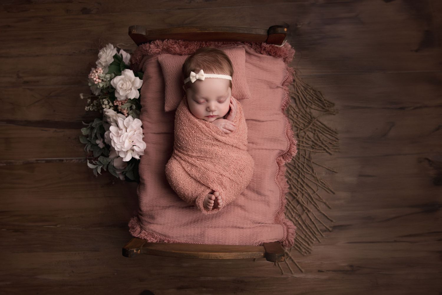 Newborn baby laying iin baby bed prop