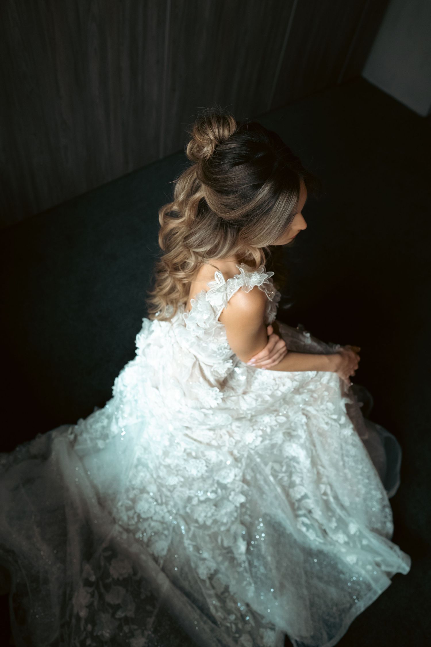 Overhead view of bride in elaborate white lace wedding gown with sparkling details.
