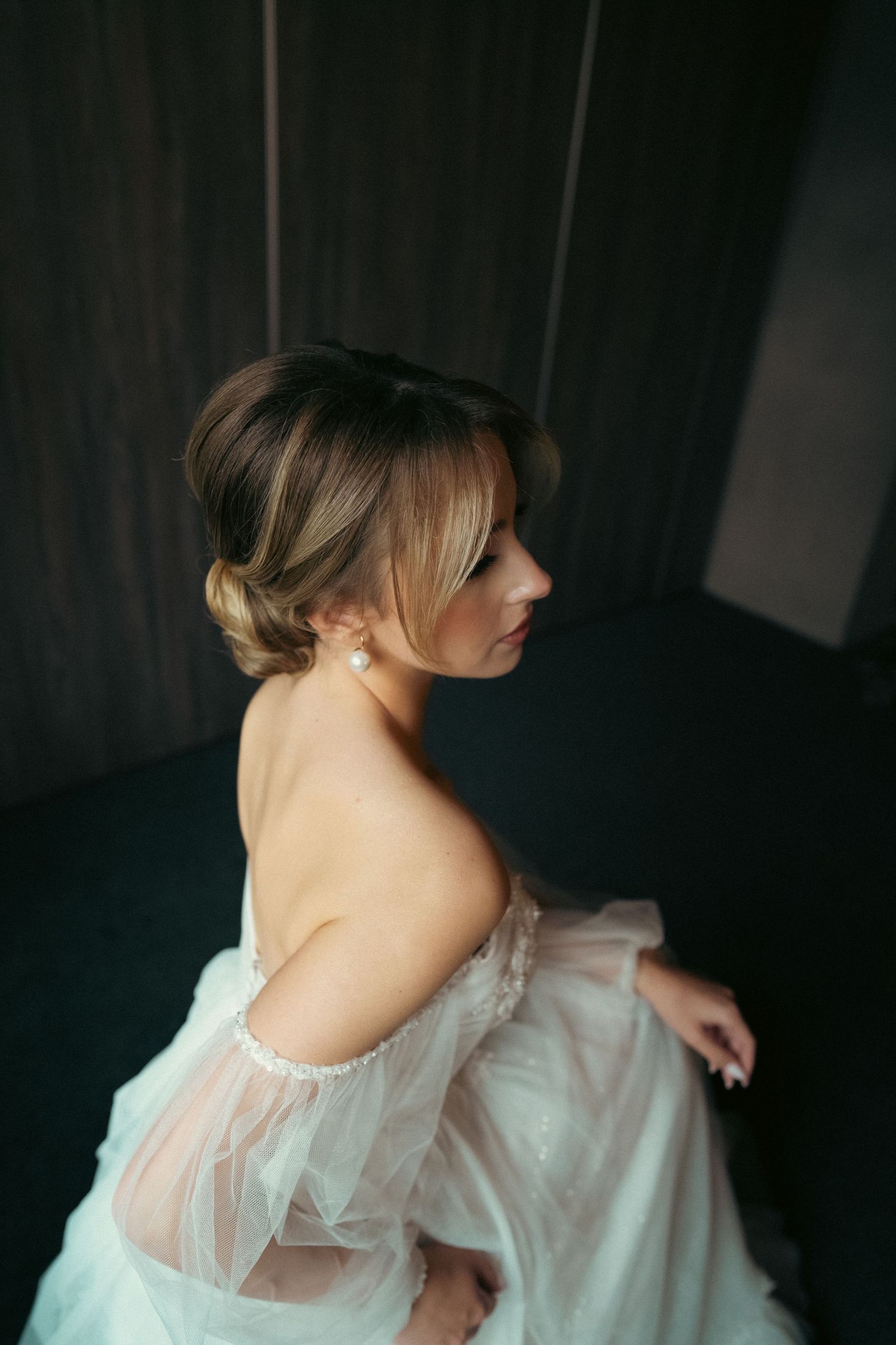 Romantic boudoir photography showing delicate white lace details in moody lighting.