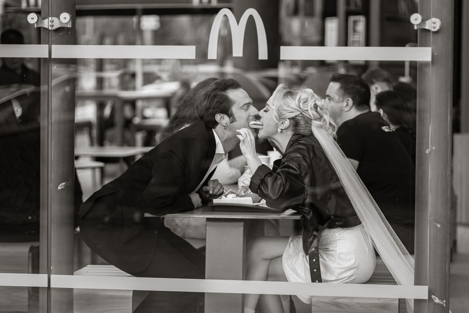 A couple shares a romantic moment at a McDonald's restaurant table.