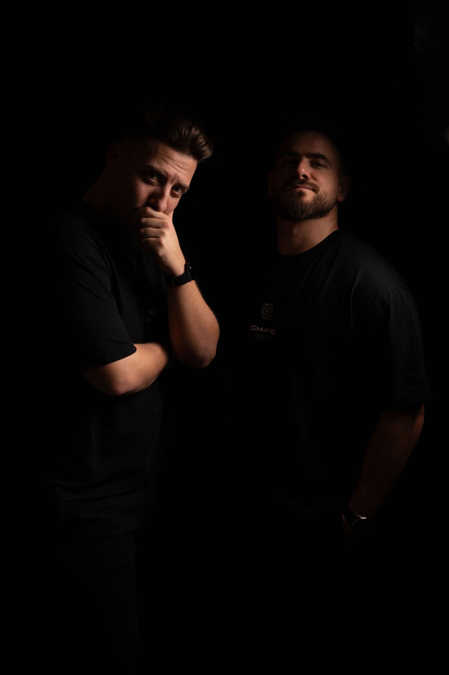 Artistic low key portrait showing intimate interaction between two people in dark setting.