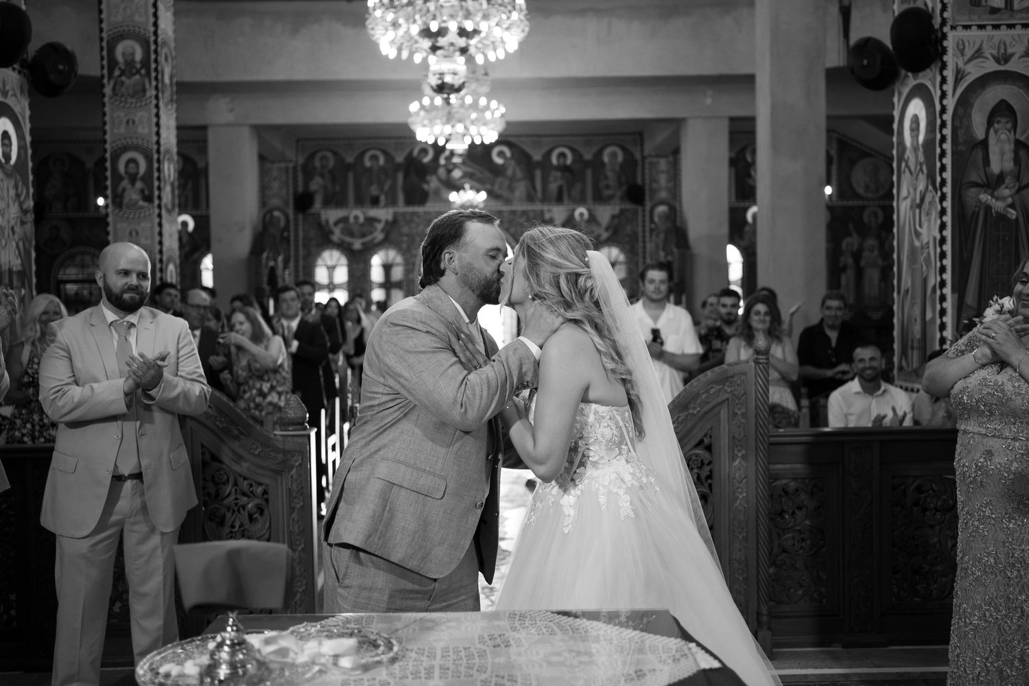 Black and white wedding reception photos show couples dancing and celebrating under elegant chandeliers.