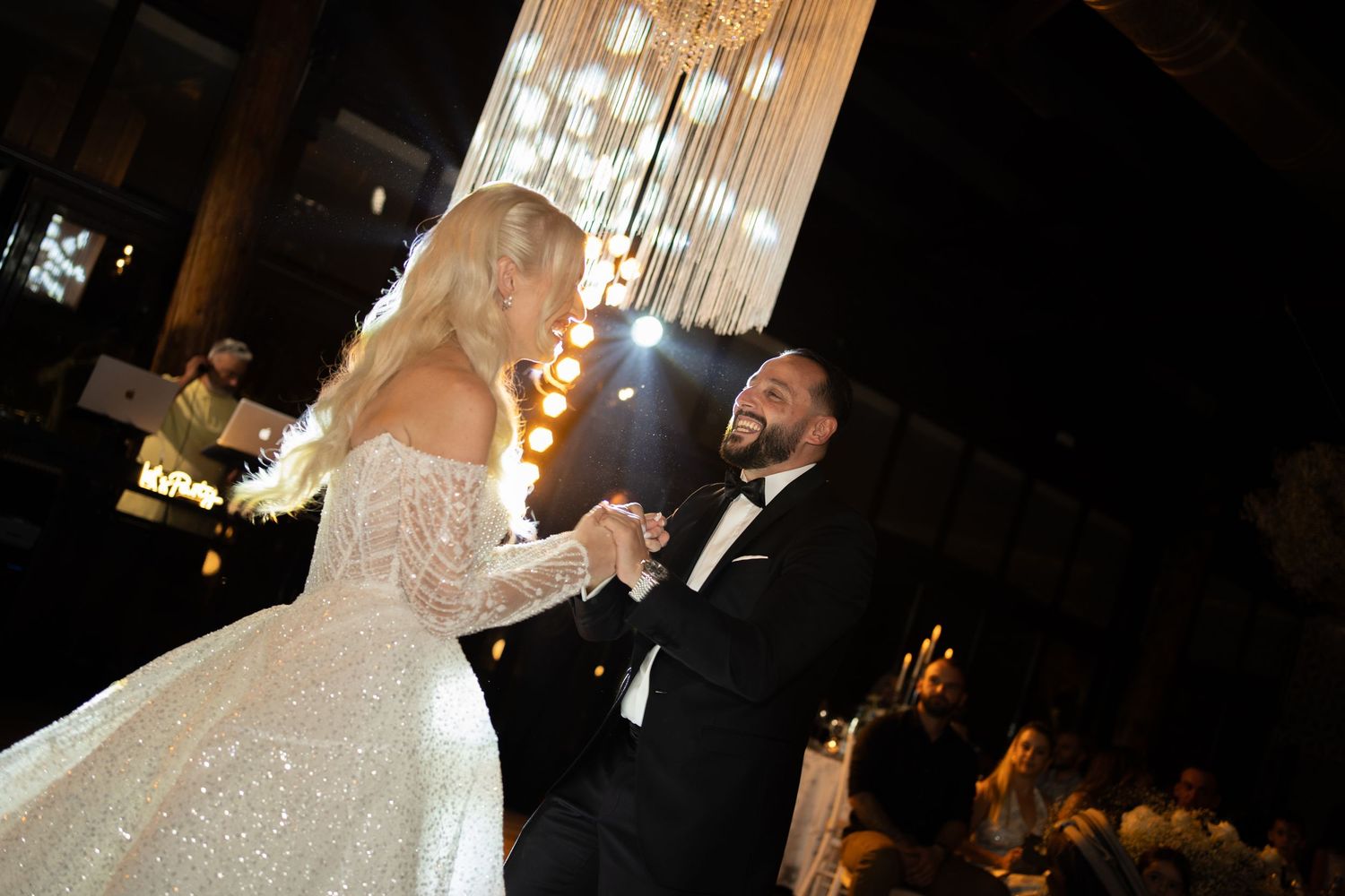A wedding reception scene with elegant crystal chandeliers and romantic lighting.
