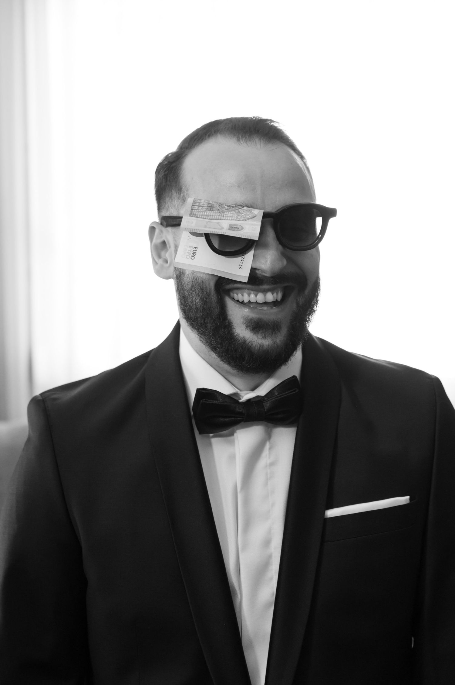 A series of black and white photos showing a groom in a tuxedo and sunglasses smiling.