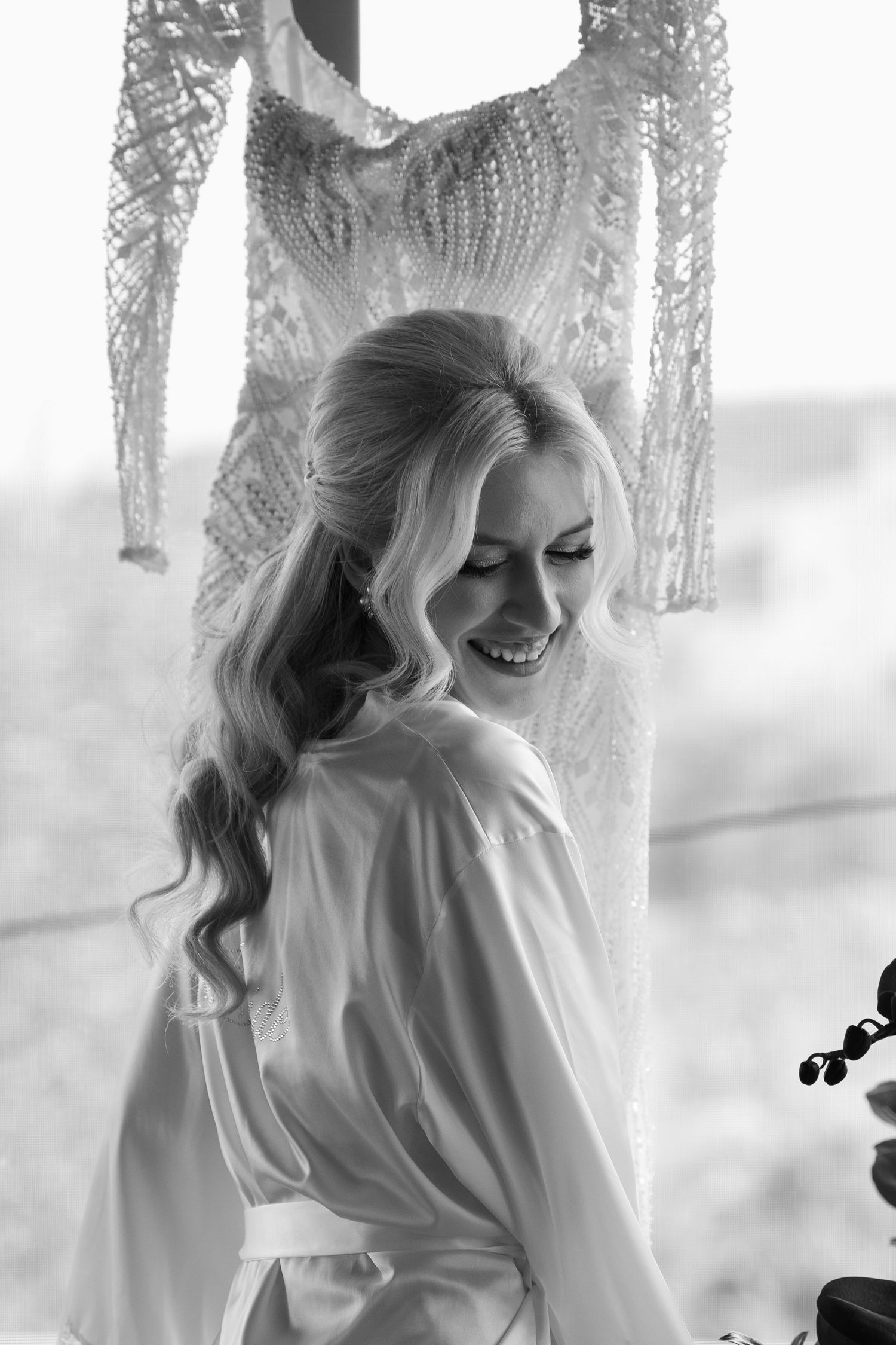 Soft black and white portrait showing ethereal bridal styling with flowing blonde hair.