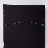 Black rectangular board with a silver wire hanger attached to the back for wall mounting.