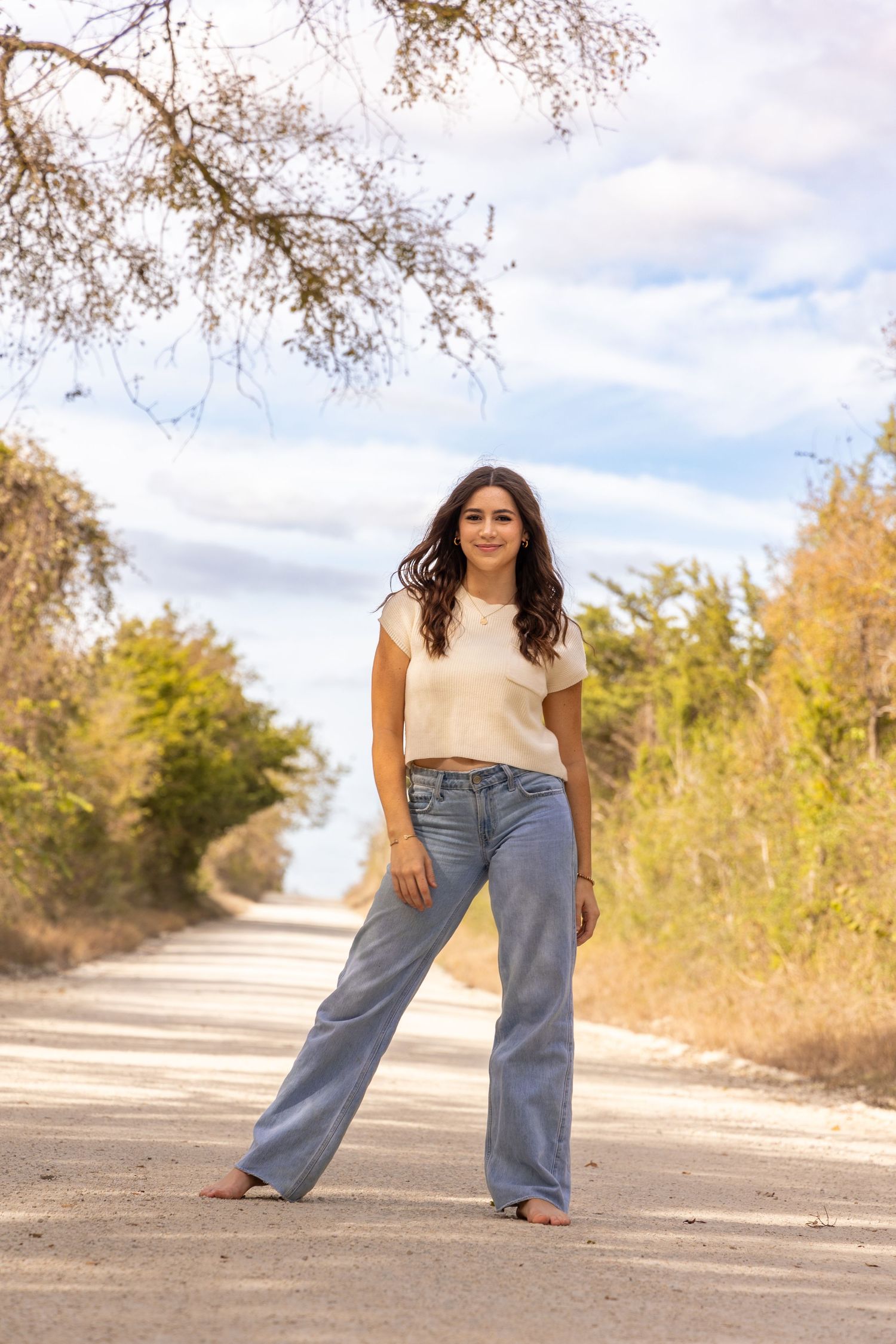 Four sequential photos showing a person in blue jeans and white top posing on a rural road during autumn.