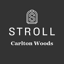 A dark gray logo for Stroll Carlton Woods featuring a minimalist arch design and white text on charcoal background stroll magazine