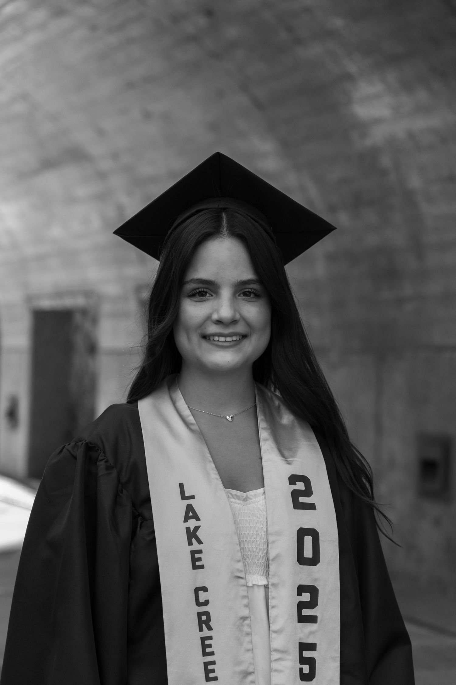 Black and white graduation portraits showing a graduate in cap and gown with Class of 2012 sash smiling at camera.