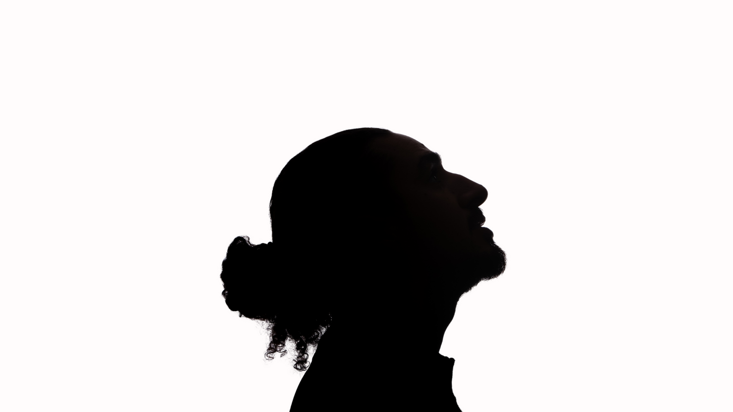 Side profile silhouette of a woman with hair bun against a white background.