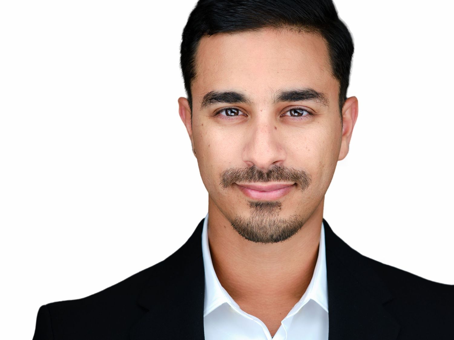 Professional headshot of a man with short dark hair and beard wearing a black suit and white shirt.