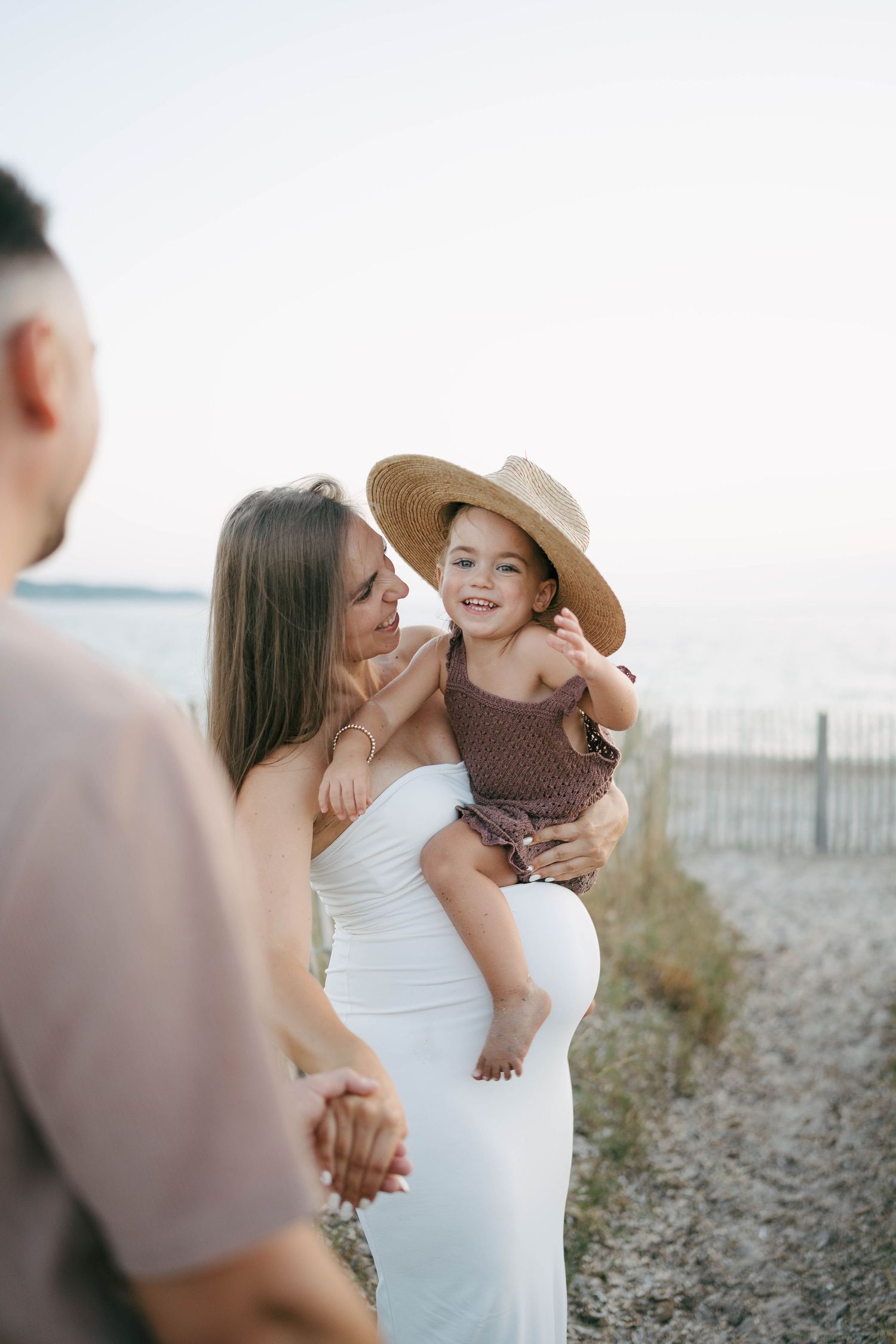 Un tendre moment de famille capturé dans une série de photos au bord de la plage montrant des interactions affectueuses