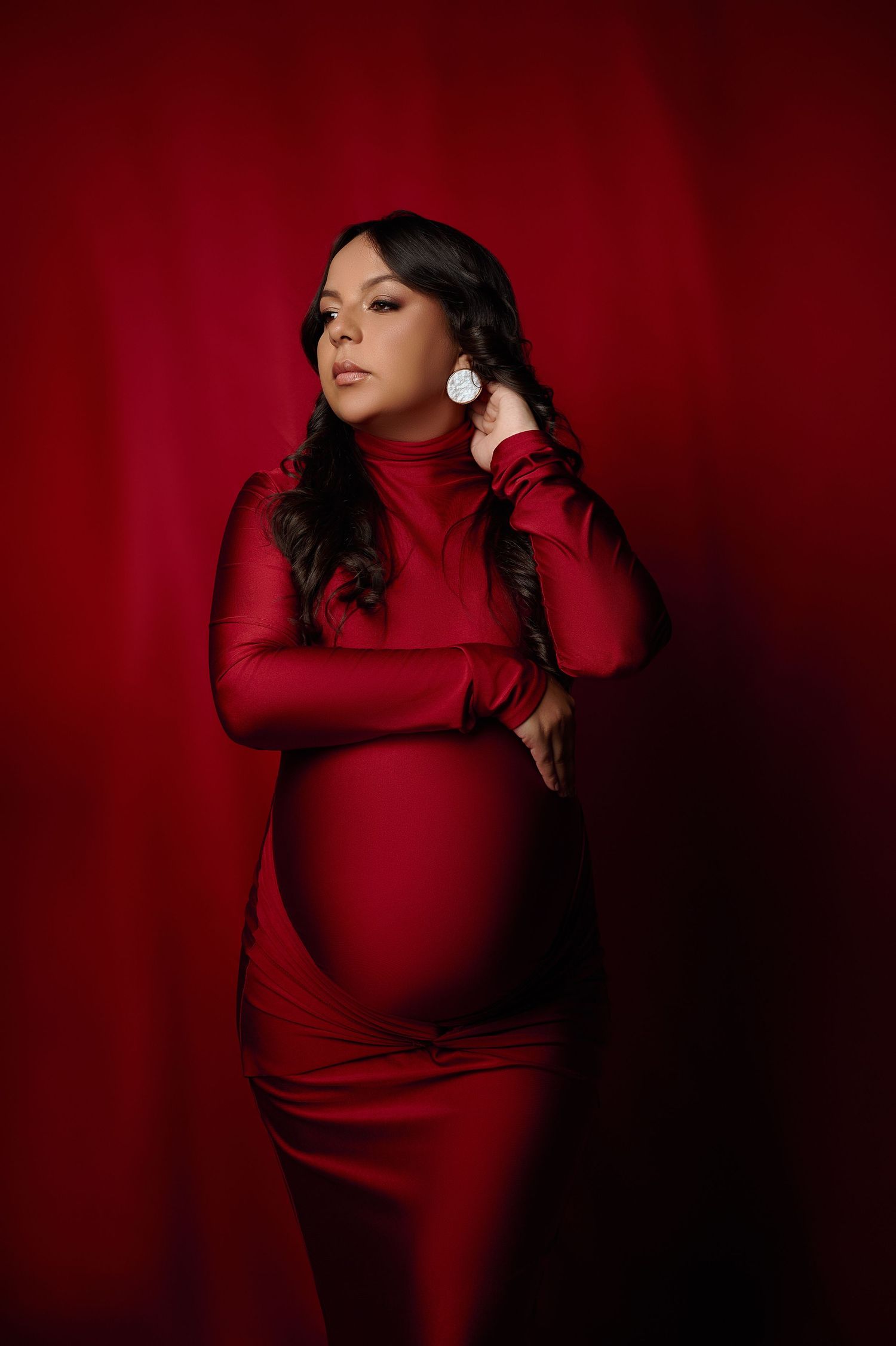 Retrato de gestante elegante e atemporal, gestante com vestido justo vermelho de gola alta