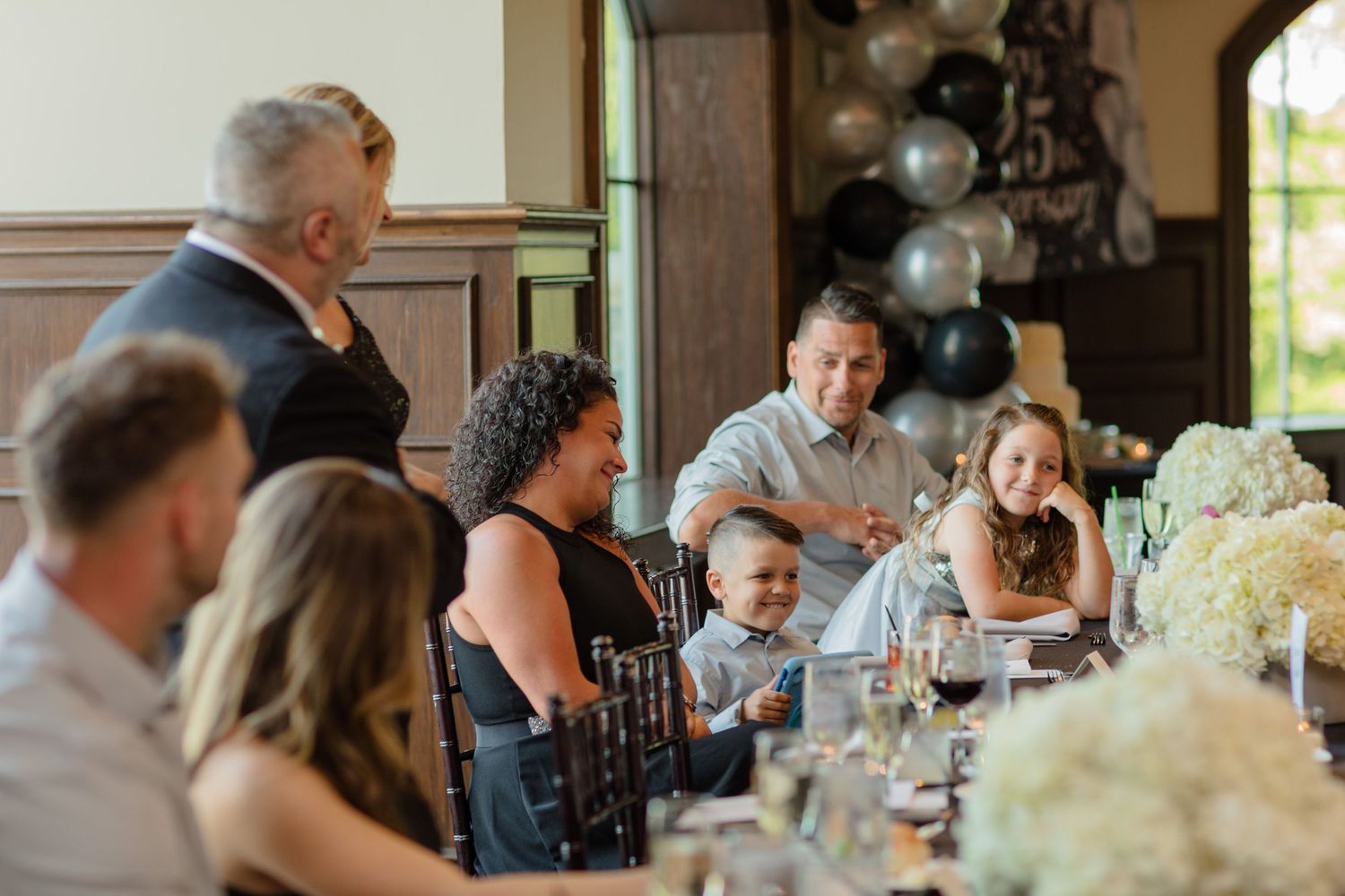Guests share laughter and conversation during a formal dining event.