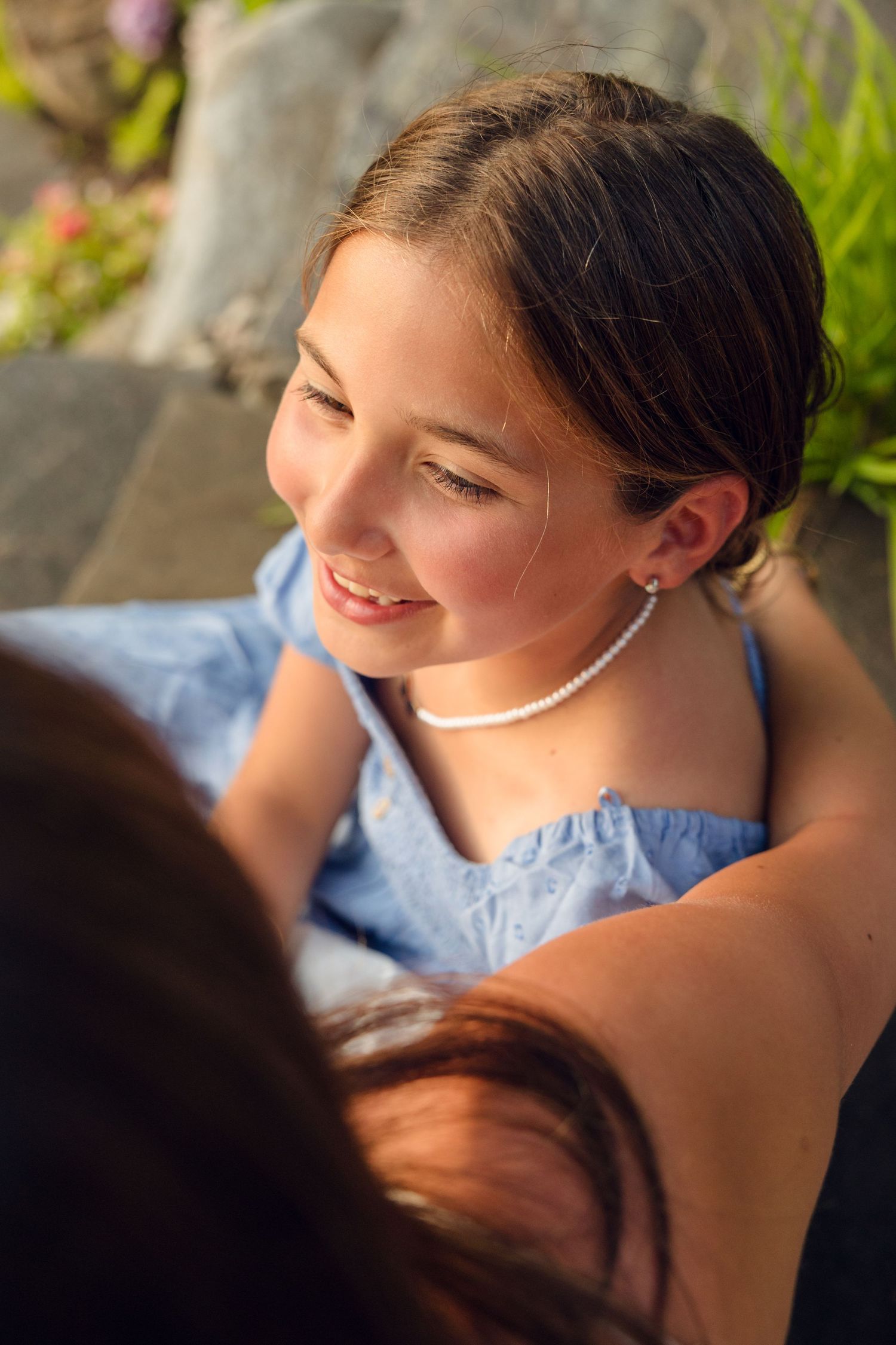 Close-up profile shots showing person wearing pearls and blue dress.