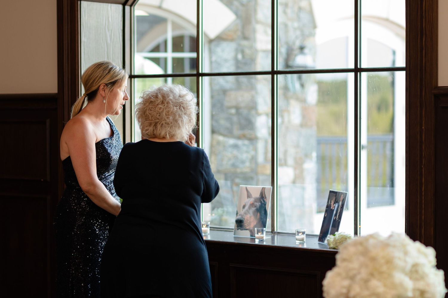 Large windows illuminate an elegant indoor venue space with dark wood details.