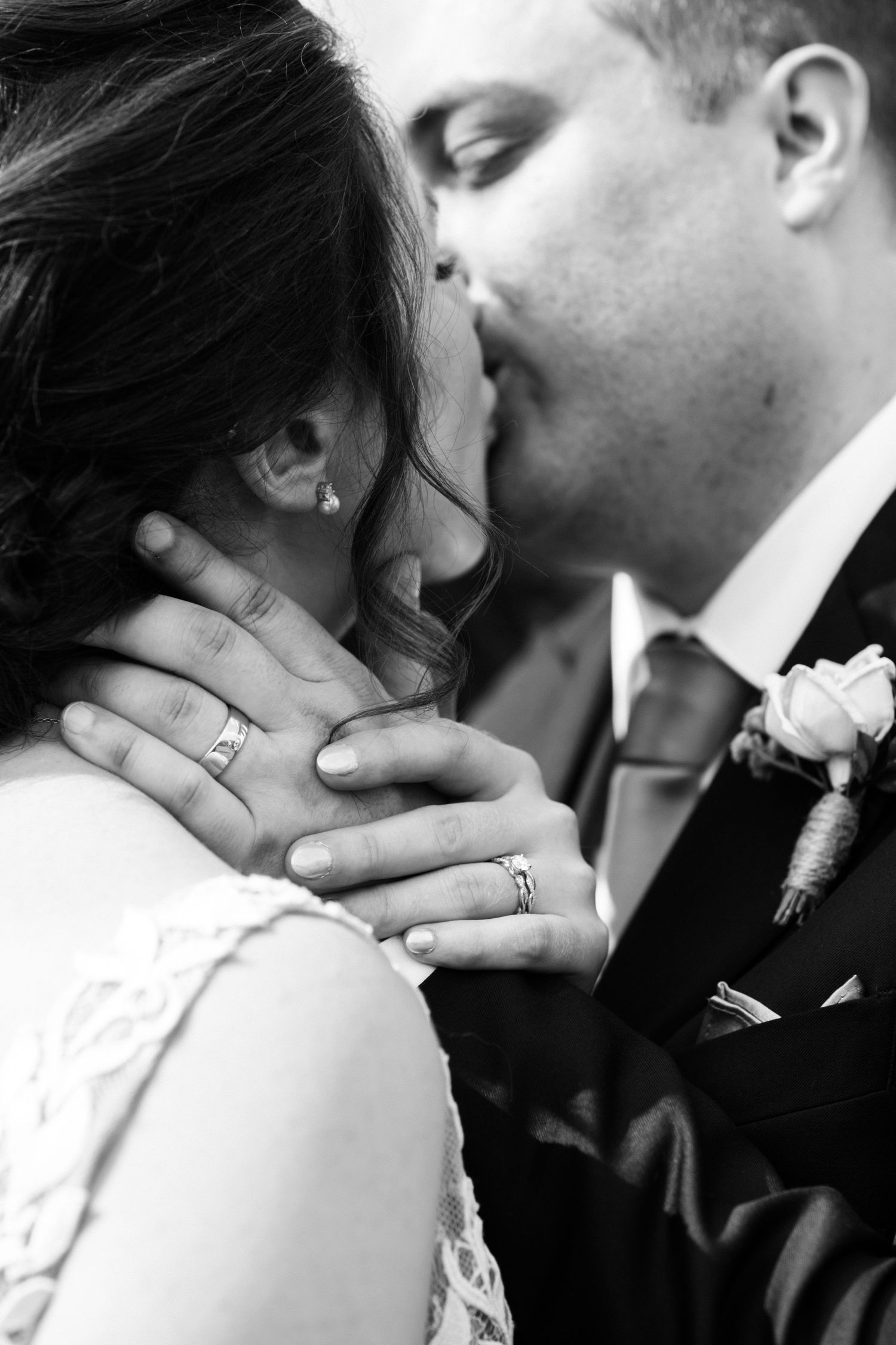 A black and white close-up of wedding rings and an intimate moment.