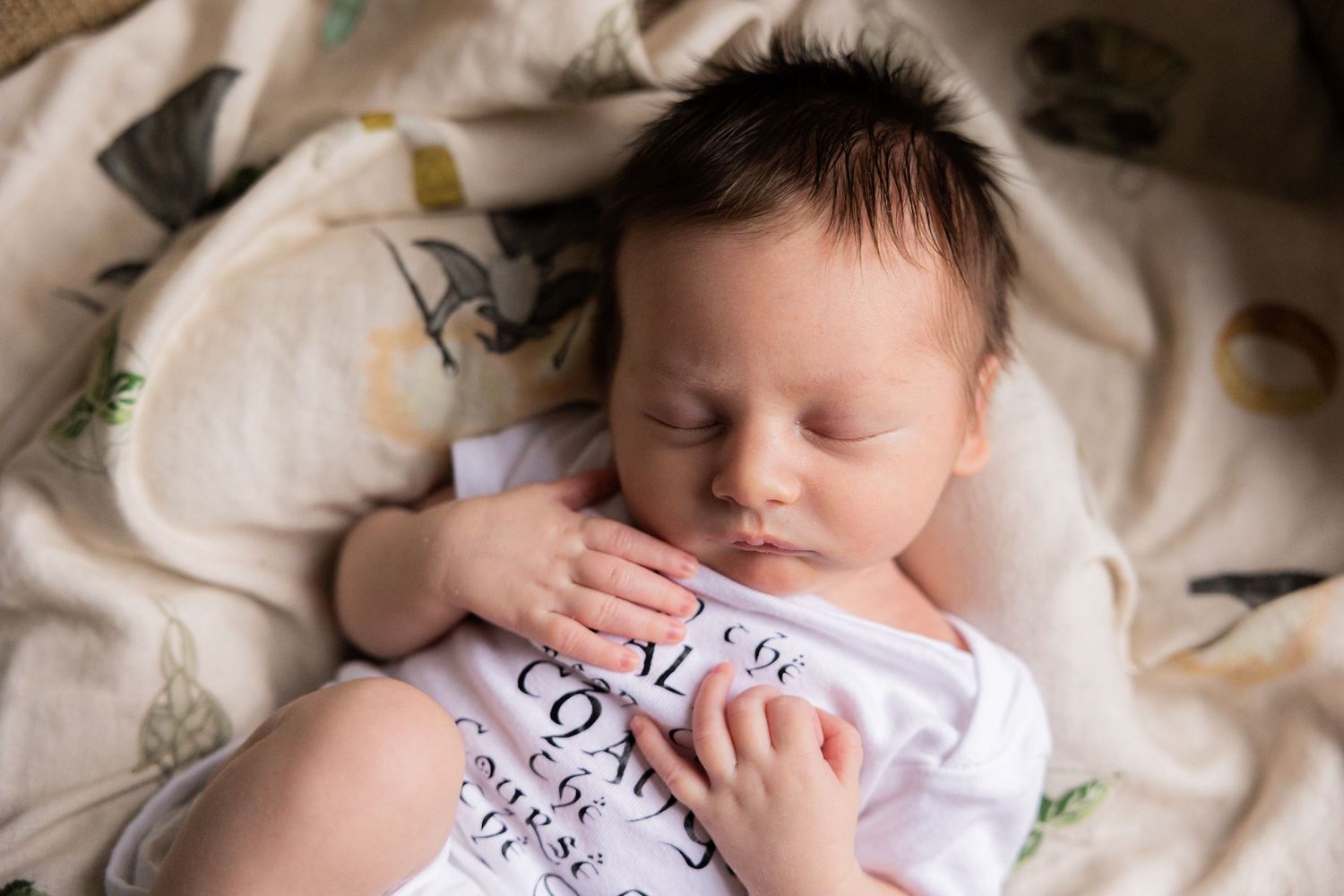 Peaceful newborn photography session on textured white blanket.