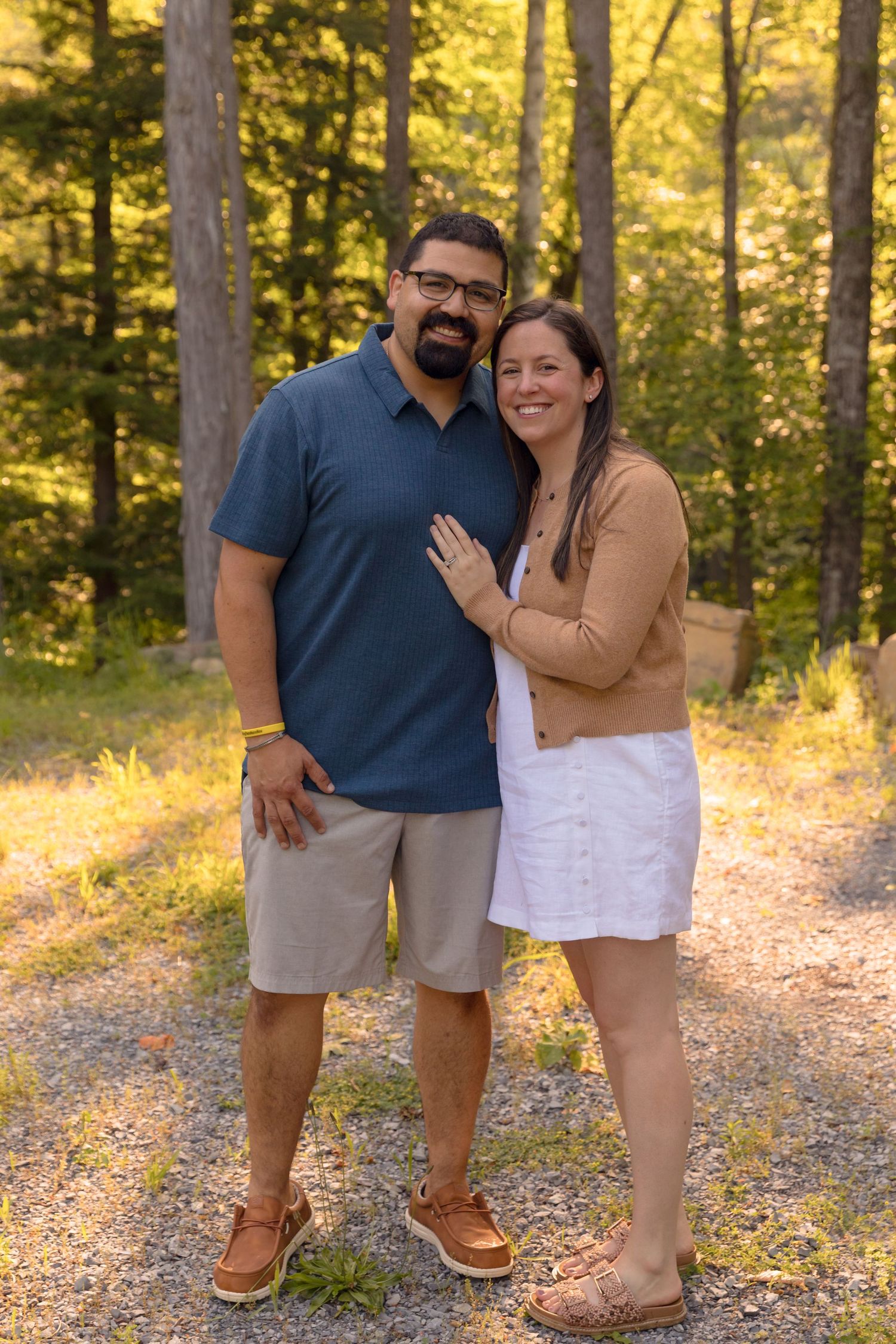 Casual family portraits in golden sunlight on forest path.