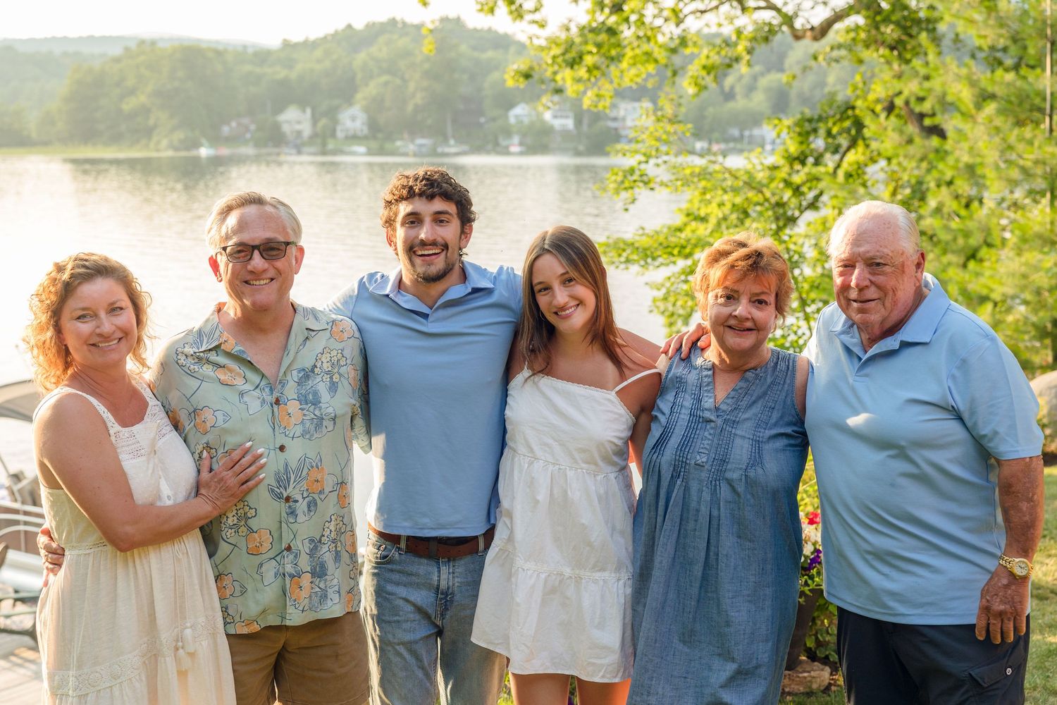 Extended family group poses together outdoors in casual summer clothing.