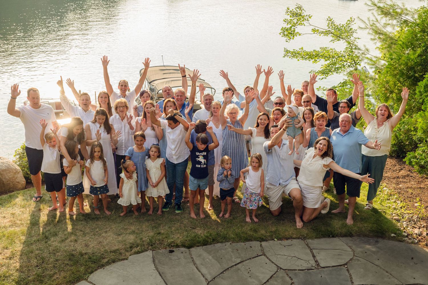 Large group photo of family members celebrating together by the lake.
