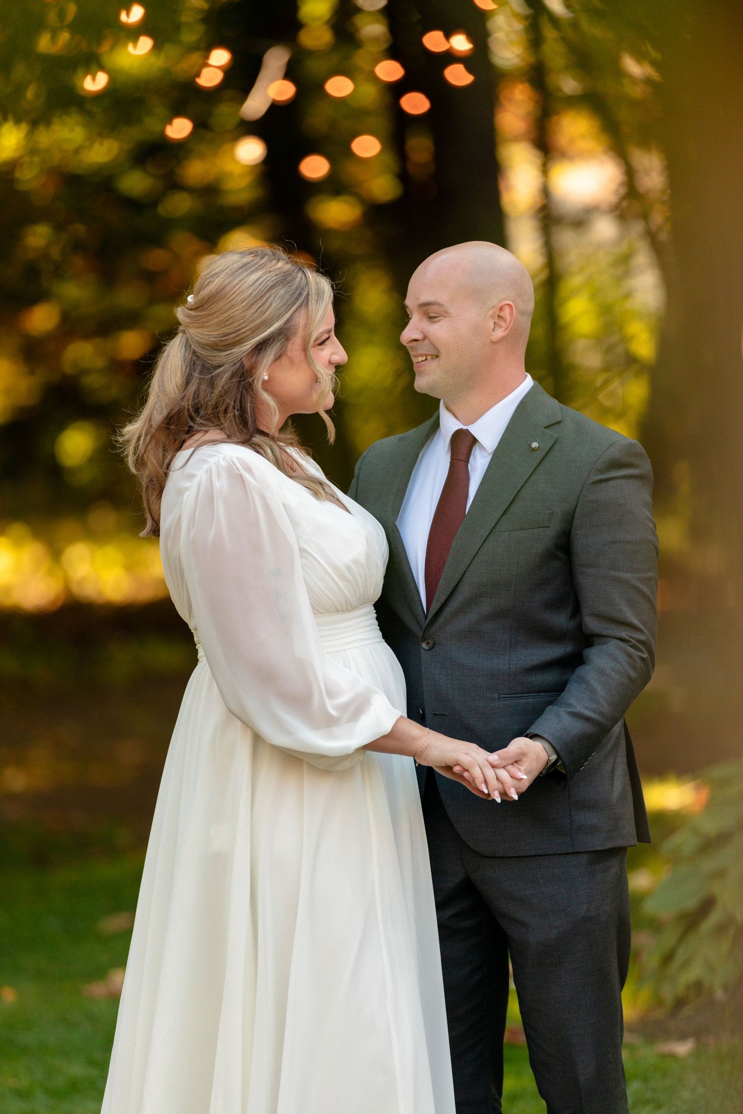 Romantic couple in formal attire sharing intimate moments in golden sunset light.