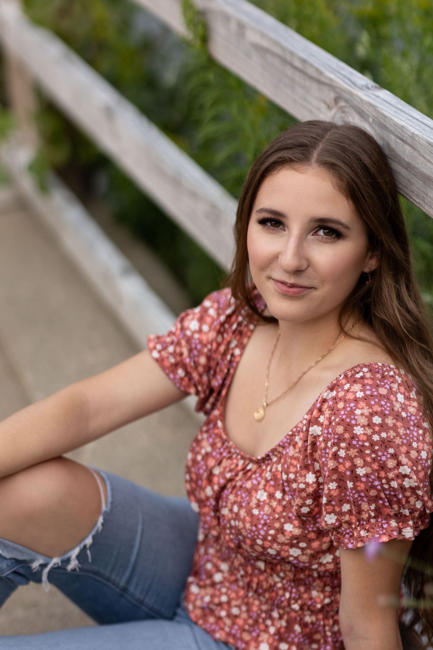Portrait series showing casual poses against wooden fence with natural lighting.