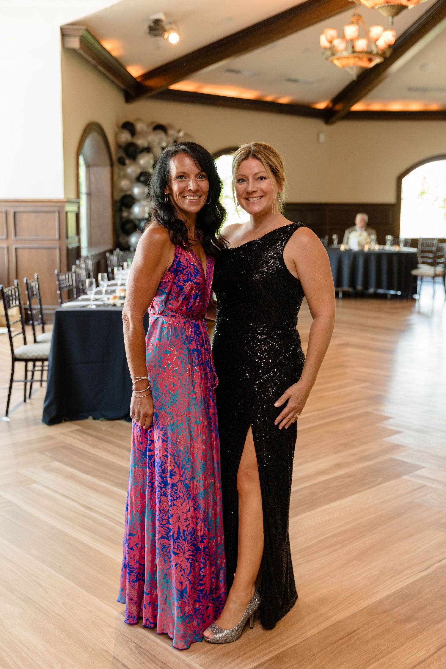 Guests socializing in an elegant reception hall with wooden beams.