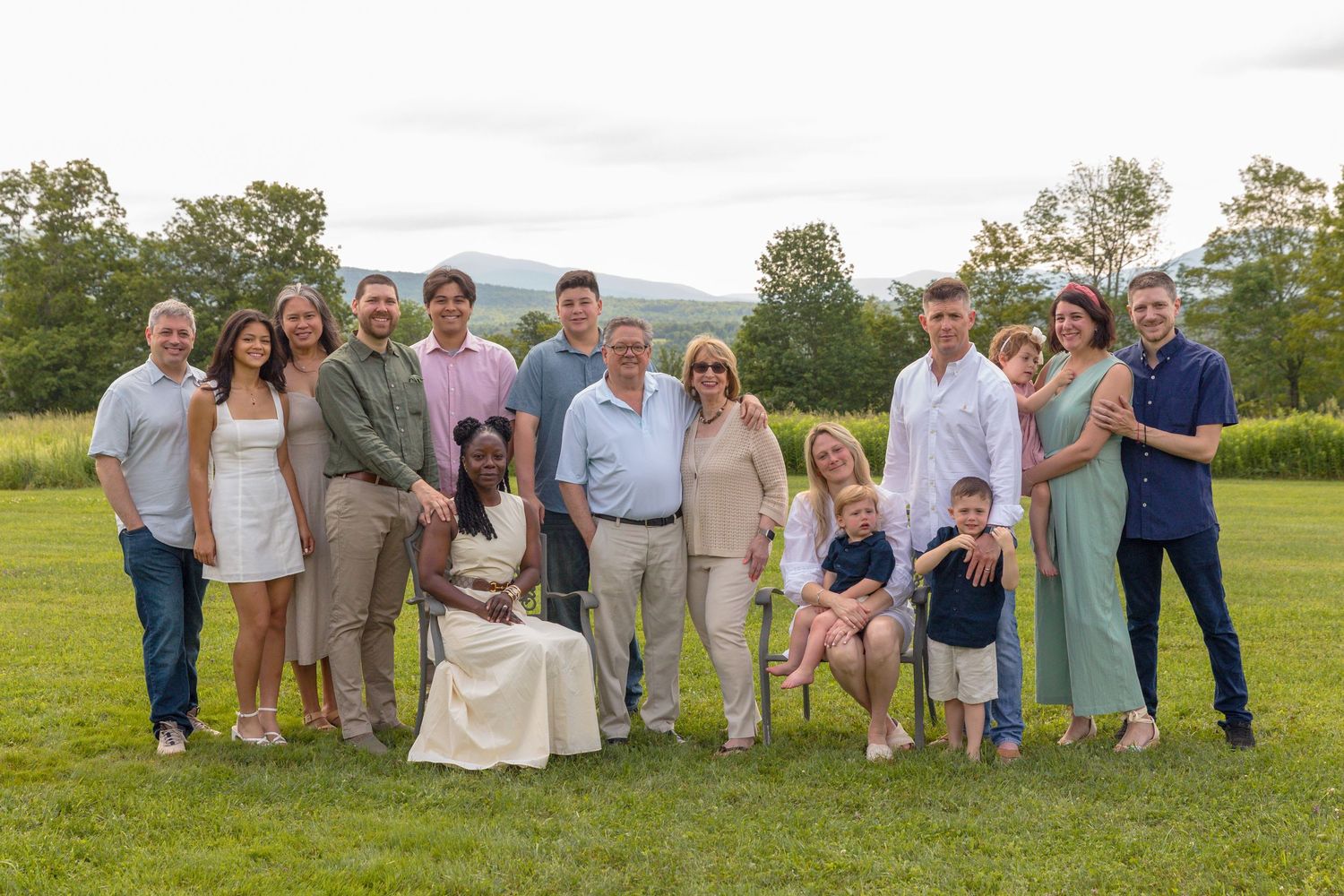 Panoramic group photo of wedding guests arranged on a grassy hillside.