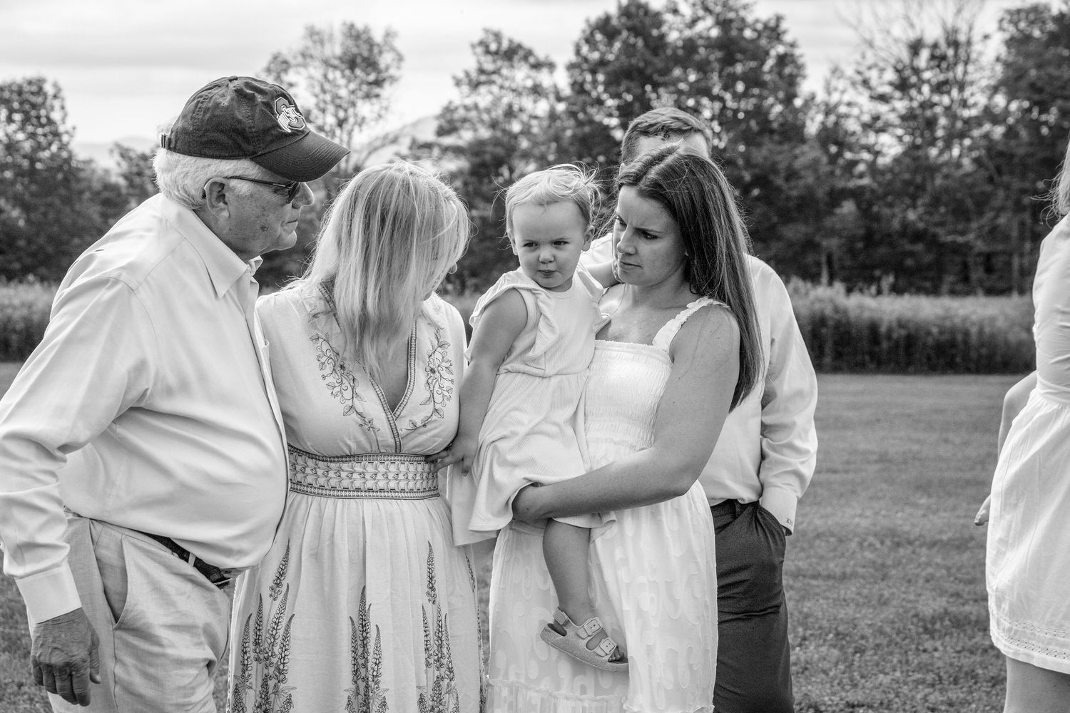 A black and white outdoor family gathering with people in light summer attire.