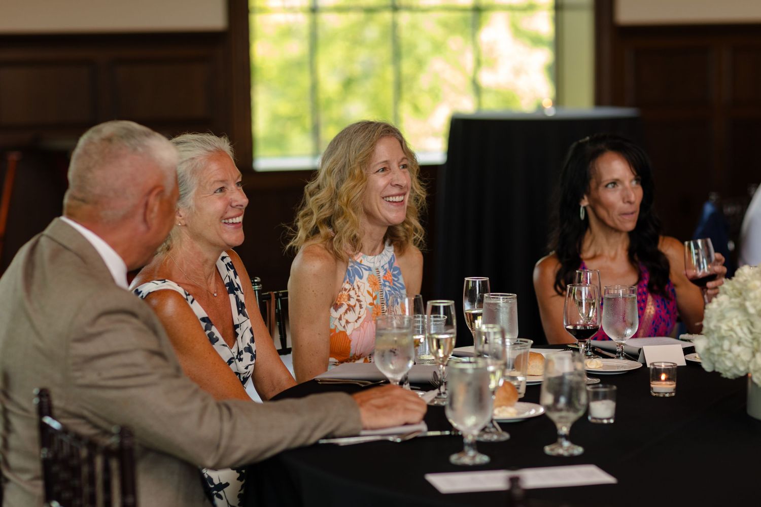 People enjoying conversation at dining tables during an elegant indoor celebration.