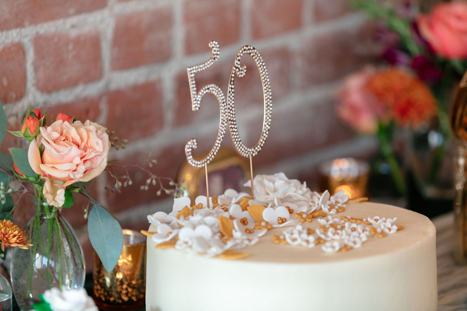 Elegant floral arrangements and decorative number signs adorn a table at a celebration.