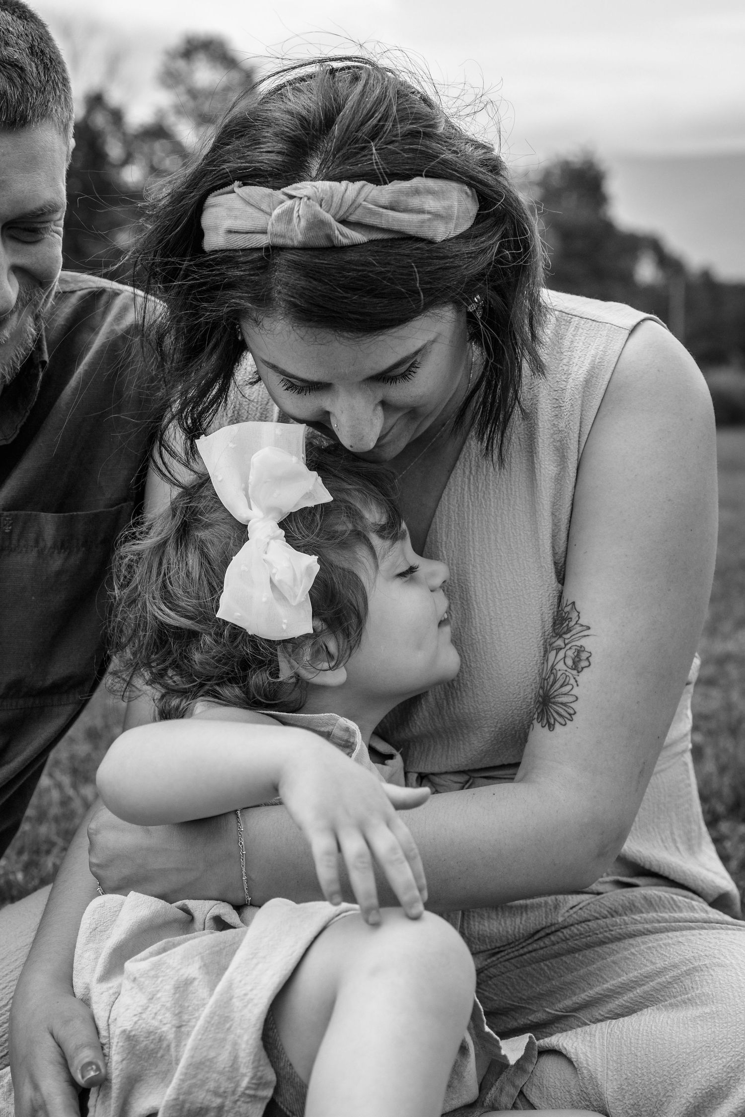 An intimate black and white moment between parent and child wearing matching hair bows.
