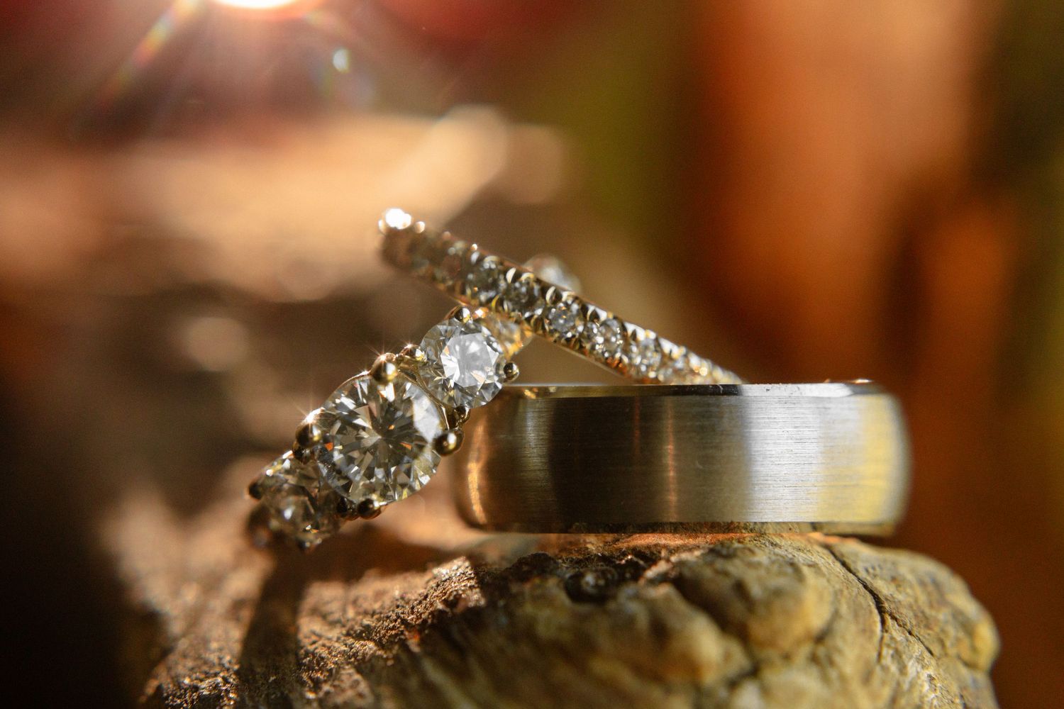 Close-up detail of sparkling wedding rings with bokeh lighting effects.