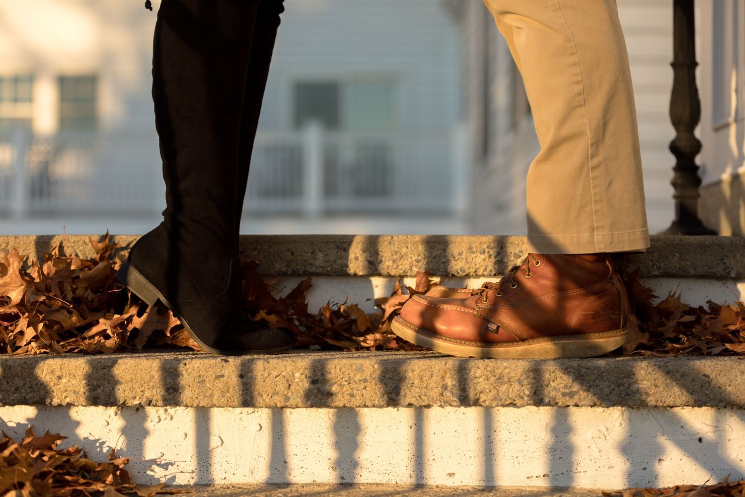 Artistic shadow pattern of couple standing on textured surface at sunset.