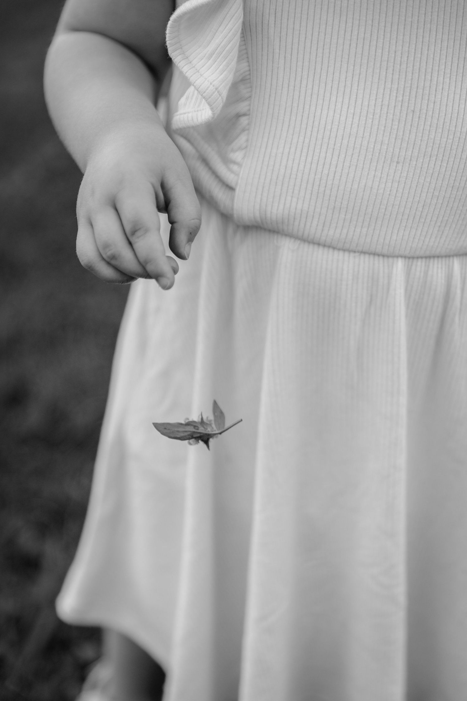 Series of black and white images showing details of a white dress and hands.