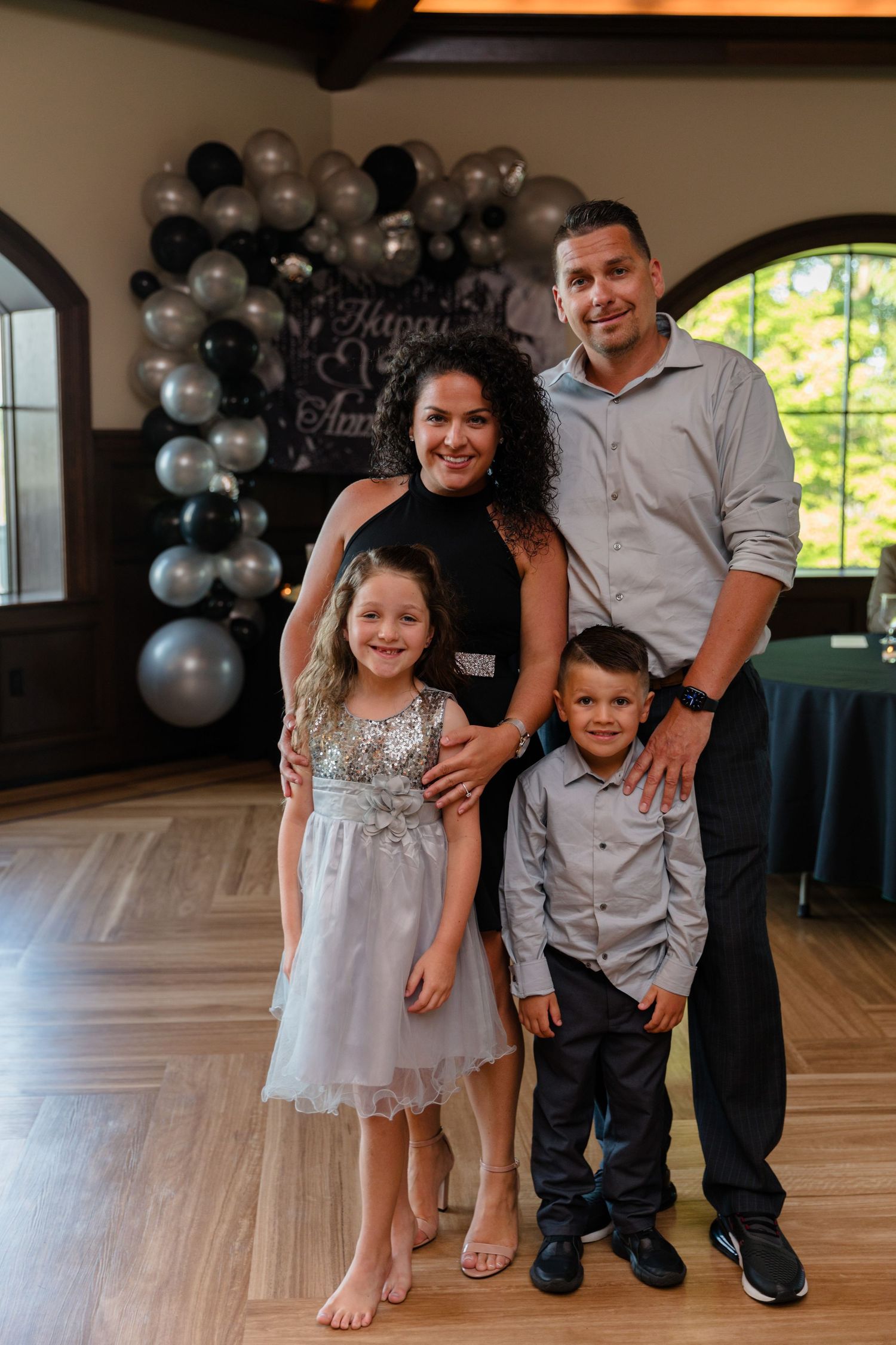A festive indoor celebration with silver balloons and wooden flooring.