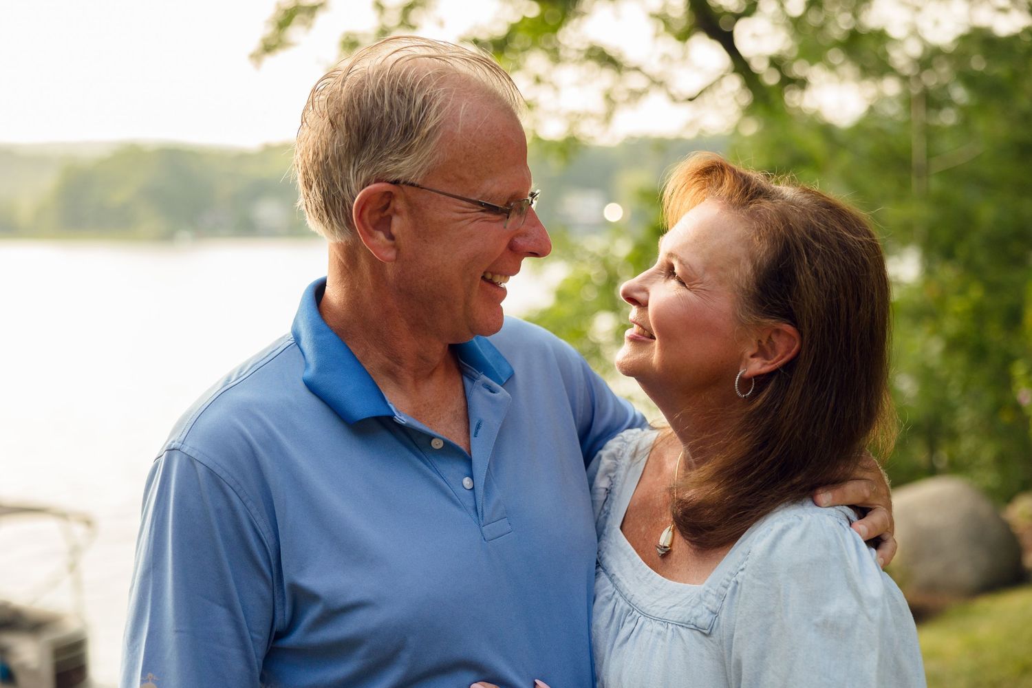 Loving couple sharing candid laughs during a lakeside photo session.